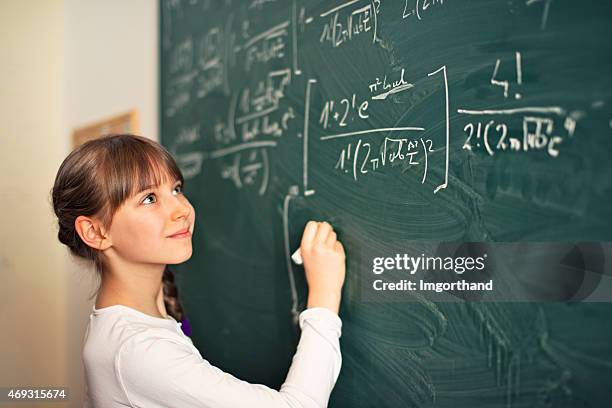 little girl writing difficult mathematics equations - mathematician stockfoto's en -beelden