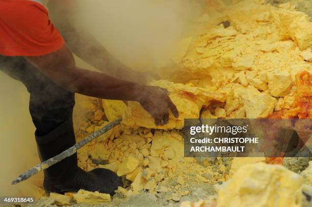 This photo taken on December 25, 2010 shows an Indonesian miner extracting blocks of sulphur with his bare hands from the bottom of the crater of...