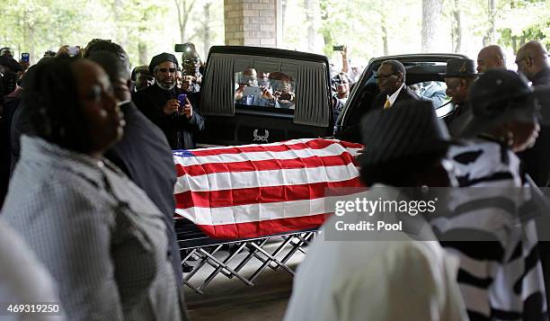 Mourners look on as the casket of Walter Scott is removed from a hearse for his funeral at W.O.R.D. Ministries Christian Center, April 11, 2015 in...