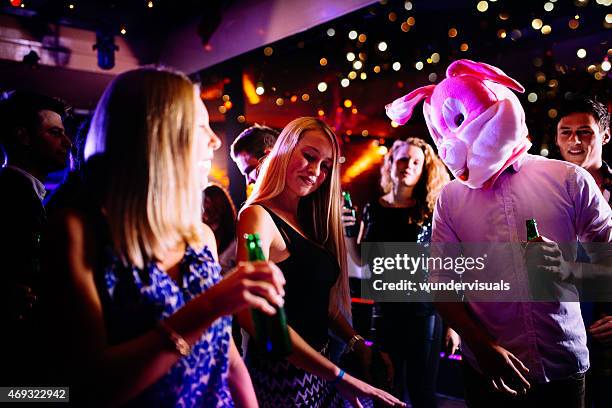 guy as bunny at party club next young woman dancing - crazy party stockfoto's en -beelden