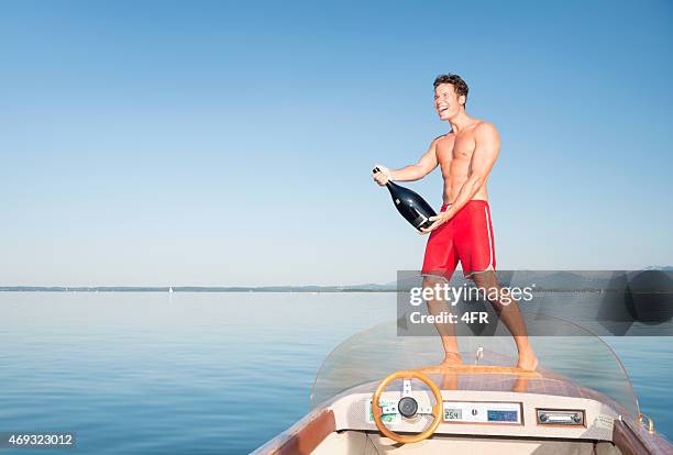 man preparing a champagne shower on a boat - first class champagne stock pictures, royalty-free photos & images