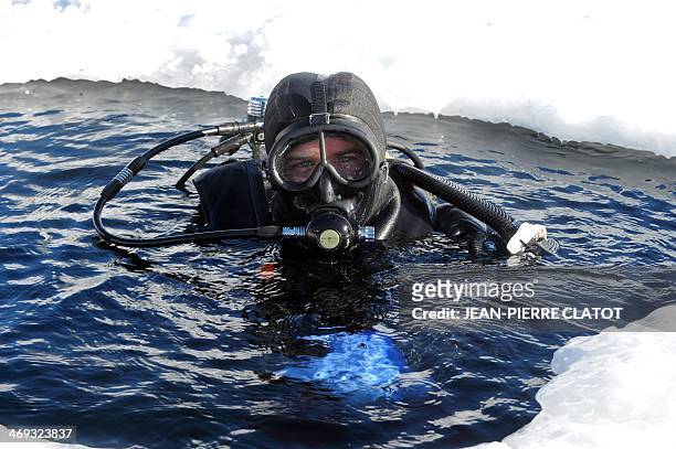 Ice diving instructor Benjamin Roch readies his gear before going under the frozen Lake of Tignes 100 meters high, in the French Alps, on February...