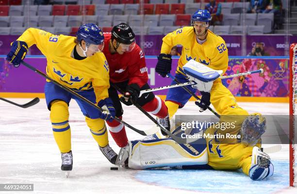 Ss30 makes a save against Nino Niederreiter of Switzerland as Nicklas Backstrom defends during the Men's Ice Hockey Preliminary Round Group C game on...