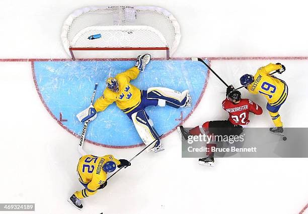 Henrik Lundqvist of Sweden makes a save against Nino Niederreiter of Switzerland in the first period during the Men's Ice Hockey Preliminary Round...