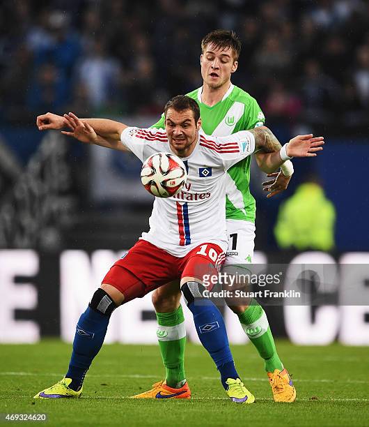Robin Knoche of Wolfsburg is challenged by Pierre Michel Lasogga of Hamburg during the Bundesliga match between Hamburger SV and VfL Wolfsburg at...