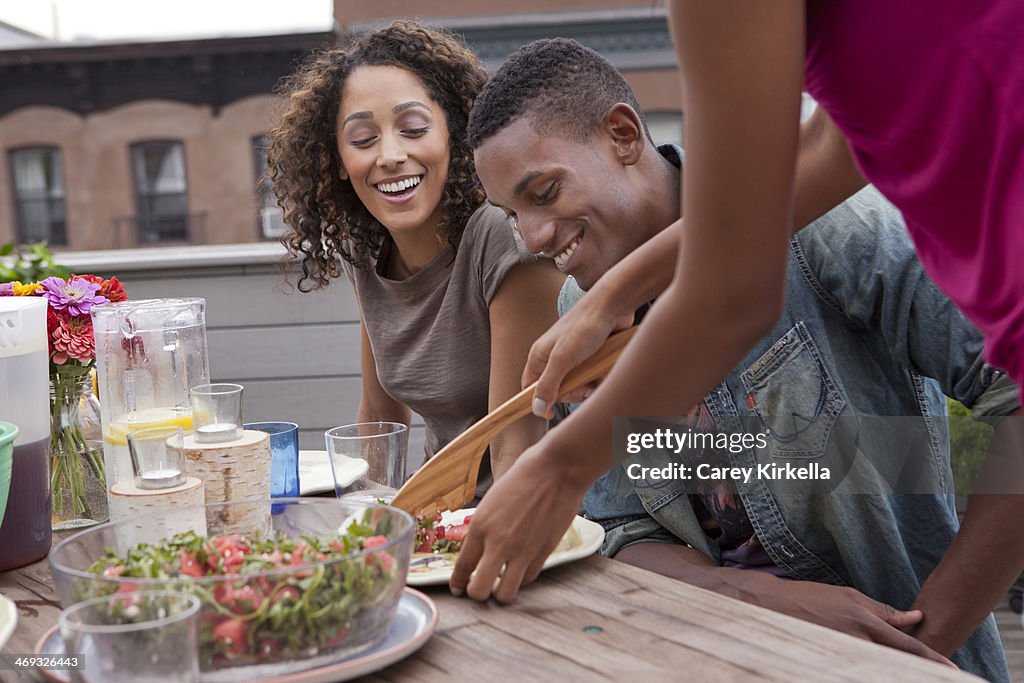 Couple being served food at a roof party