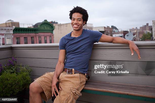 african american man with a beer on a roof deck - black shorts stockfoto's en -beelden