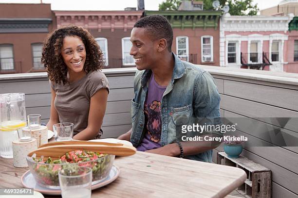 couple sitting at a picnic table at a roof party - brooklyn bowl stock pictures, royalty-free photos & images