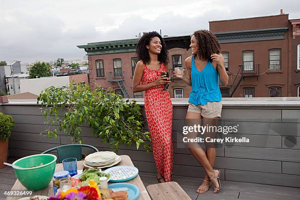 two women at a roof party - rooftop bbq stock pictures, royalty-free photos & images