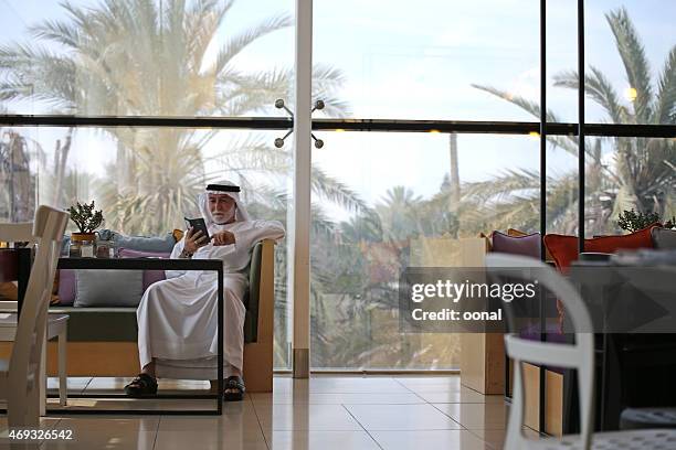 arabian man working on smart phone - daily life in abu dhabi stock pictures, royalty-free photos & images