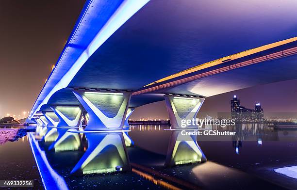 garhoud bridge in dubai with festival city in the background - burj al arab night stock pictures, royalty-free photos & images