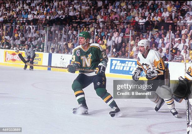 Brian Bellows of the Minnesota North Stars and Bryan Trottier of the Pittsburgh Penguins skate in front of the net during Game 5 of the 1991 Stanley...