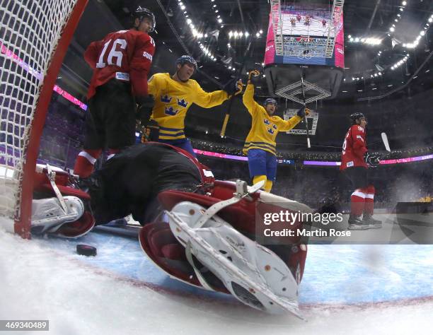 Alexander Steen and Patrik Berglund of Sweden celebrate a goal by Daniel Alfredsson in the third period against Reto Berra of Switzerland during the...