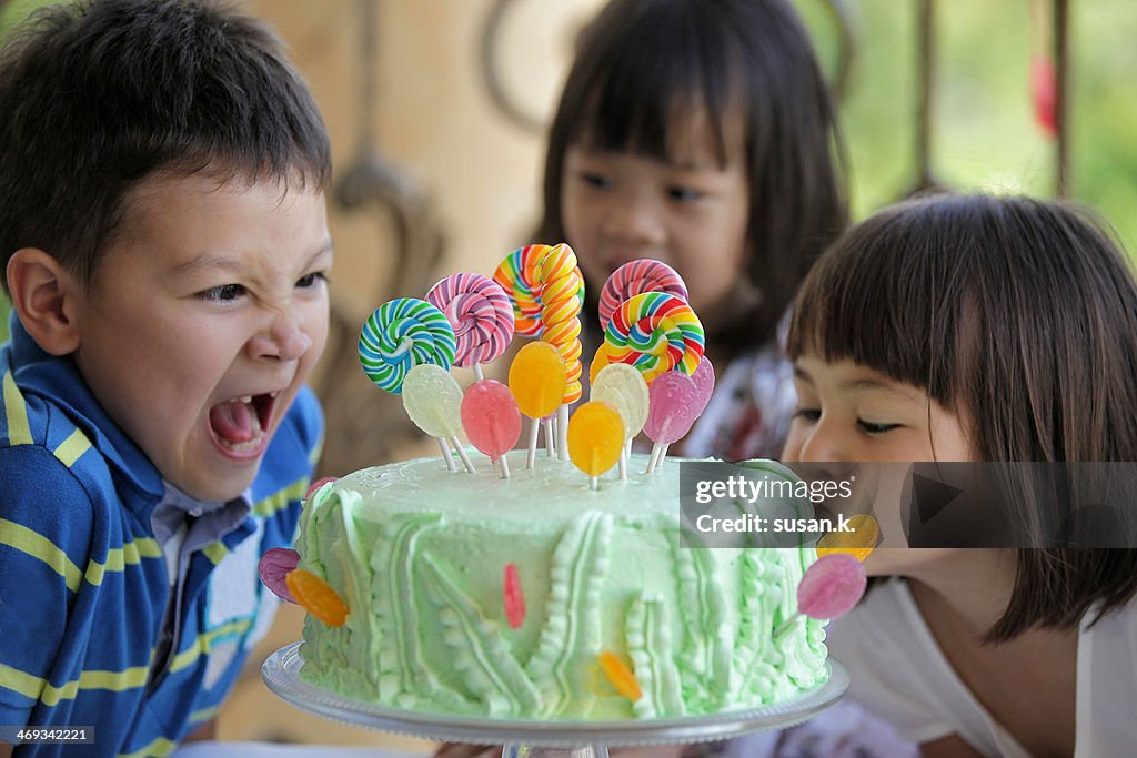 Boy and girl making scarily hungry face on cake