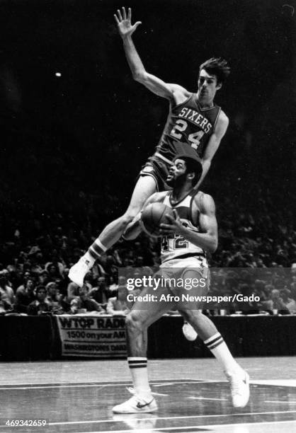 Philadelphia 76ers defender Bobby James defends ball against Washington Bullets player Greg Ballard during basketball game, April 1, 1980.