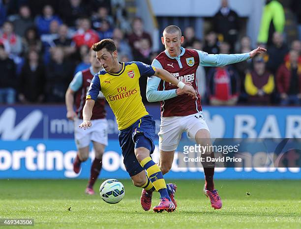 Mesut Oezil of Arsenal takes on David Jones of Burnley during the Barclays Premier League match between Burnley and Arsenal at Turf Moor on April 11,...