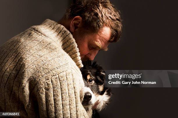 man embracing dog,studio shot - gary love stock pictures, royalty-free photos & images