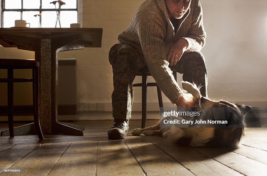 Man rubbing dog's belly