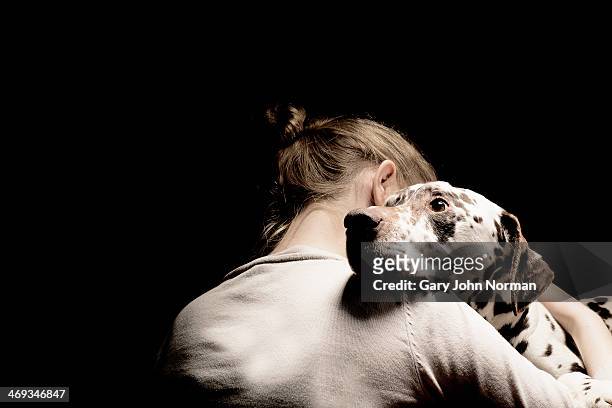 girl embracing her dog, studio shot - animale foto e immagini stock