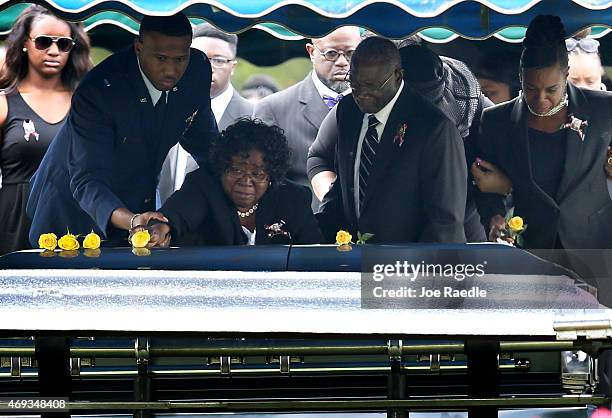 Judy Scott lays a flower on the casket of her son Walter Scott, as her husband and Walter's father, Walter Scott Sr., helps her during the burial at...