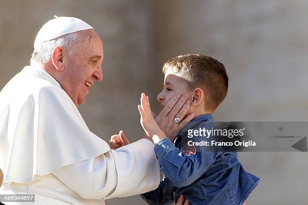 Pope Francis greets a boy as he attends a meeting with engaged couples from all over the world gathered today, on the feast of St. Valentine, in St....