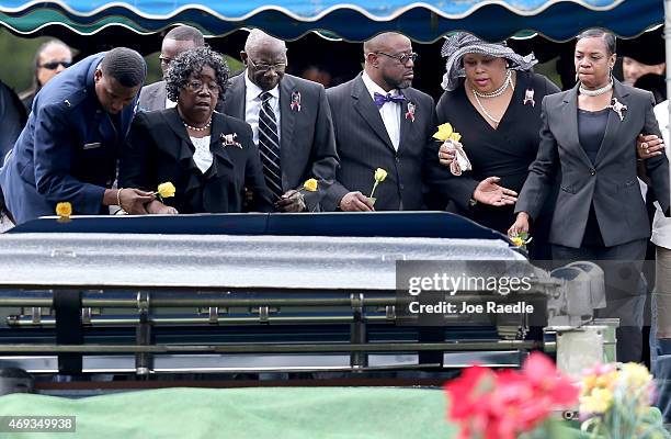 Judy Scott and Walter Scott Sr., are joined by others as they prepare to place flowers on the coffin of their son Walter Scott during the burial...