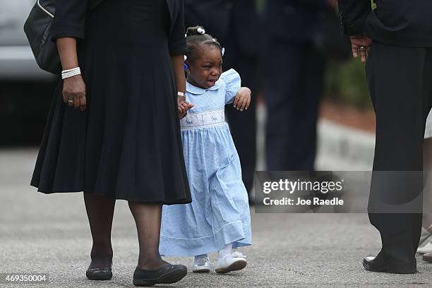 Young child walks among mourners as they attend the funeral service for Walter Scott at the W.O.R.D. Ministries Christian Center, after he was...