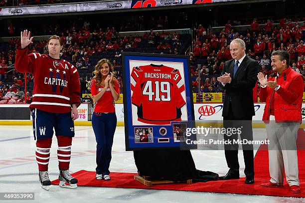 Nicklas Backstrom of the Washington Capitals waves to the crowd during a ceremony honoring Backstrom as the all-time franchise leader in assists as...