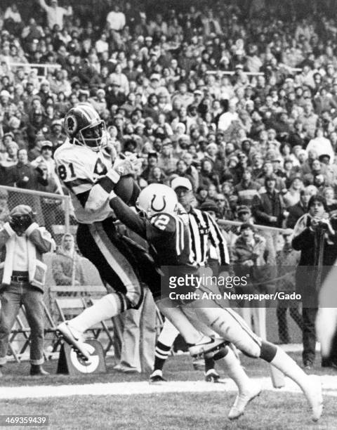 Photograph of a football game of the Baltimore Colts vs Washington Redskins, with Skin's Art Monk, Joe Theisman, and Baltimore's Derrick Hatchett,...
