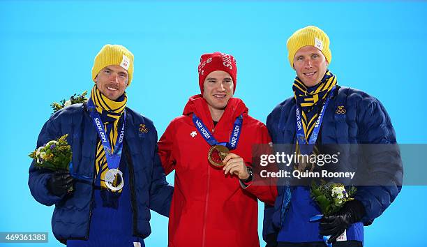 Silver medalist Johan Olsson of Sweden, gold medalist Dario Cologna of Switzerland and bronze medalist Daniel Richardsson of Sweden celebrate on the...