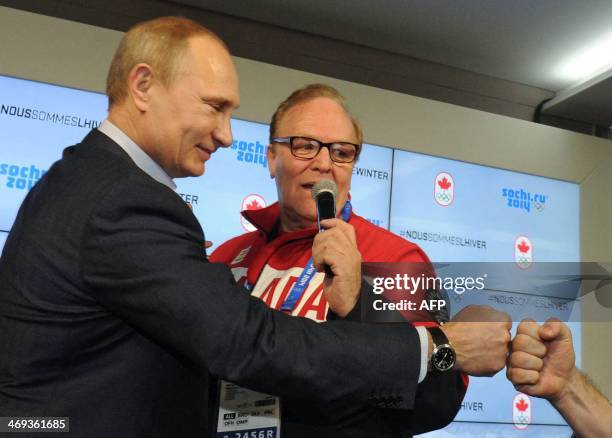 Russian President Vladimir Putin shares a greeting as he is led on a tour by the Chairman of the Canadian National Olympic Committee Marcel Aubut at...