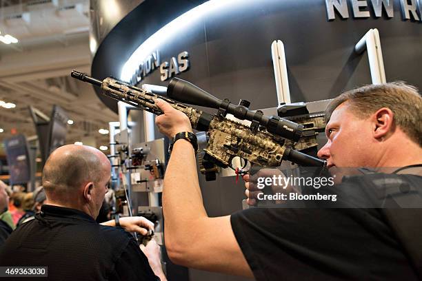 An attendee sights a rifle in the Sig Sauer, Inc. Booth on the exhibition floor of the 144th National Rifle Association Annual Meetings and Exhibits...