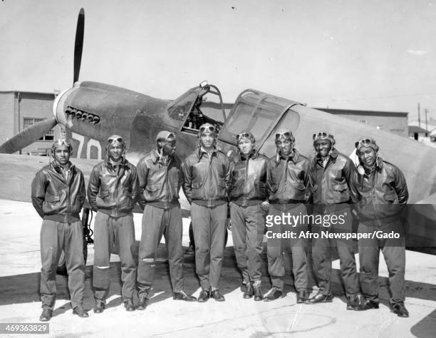 Tuskegee Airmen stand with an airplane and prepare to receive commissions and wings from Colonel Kimble, Commanding Officer of the Tuskegee Army...