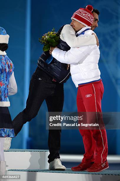 Gold medalist Martin Fourcade of France hugs bronze medalist Evgeniy Garanichev of Russia on the podium during the medal ceremony for the Men's...