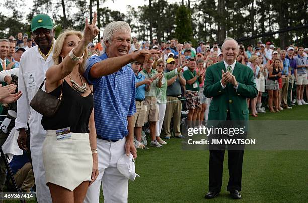 Ben Crenshaw of the US gestures to the crowd with his wife Julie after finishing the 18th hole during Round 2 of the 79th Masters Golf Tournament at...