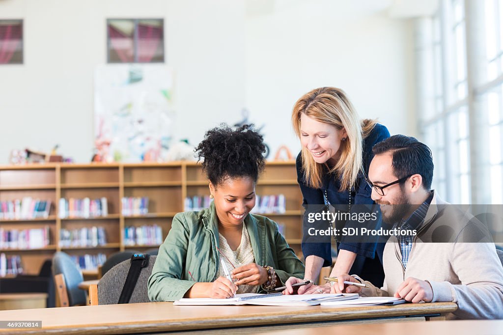 Diverse study group of adults working in large college library