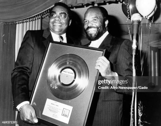 Berry Gordy, Founder of Motown Recording Company with Bob James, Motown publicist, holding an award on the 25th anniversary celebration on March 25...