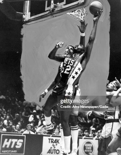 Buck Williams, basketball player for the New Jersey Nets, getting the two point lay up with Cliff Robinson, basketball player for the Washington...