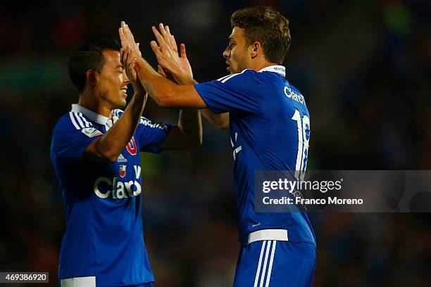 Maximiliano Rodriguez of Universidad de Chile celebrates with teammate Gonzalo Espinoza after scoring the third goal of his team during a match...