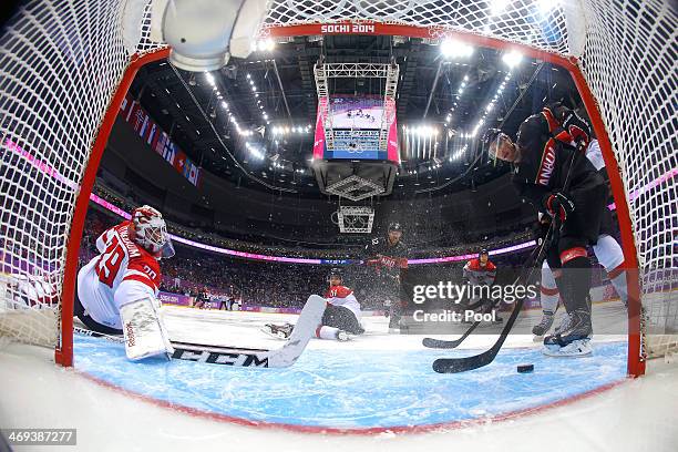 Bernhard Starkbaum of Austria gives up a goal to Jeff Carter of Canada in the second period during the Men's Ice Hockey Preliminary Round Group B...