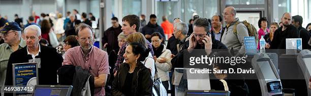 Passengers wait in longs lines for the US Airways ticketing counter at the Raleigh-Durham International Airport on February 14, 2014 in Morrisville,...