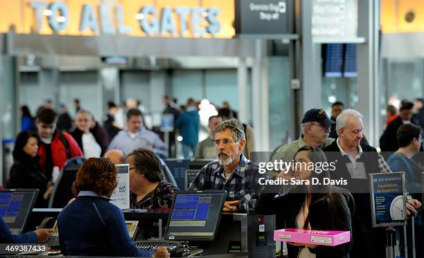 Passengers wait in longs lines for the US Airways ticketing counter at the Raleigh-Durham International Airport on February 14, 2014 in Morrisville,...