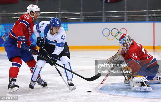 Antti Pihlstrom of Finland tries to shoot against Lars Volden of Norway during the Men's Ice Hockey Preliminary Round Group B game on day seven of...