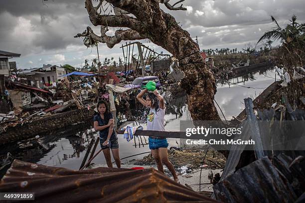 Two women shower amid destruction on November 14, 2013 in Leyte, Philippines. Typhoon Haiyan which ripped through Philippines over the weekend has...