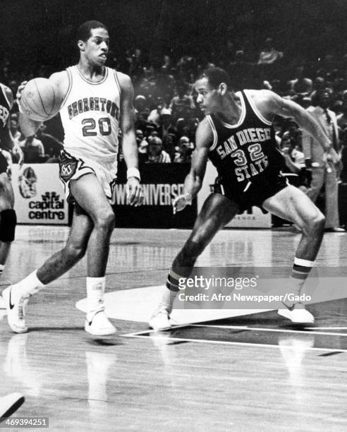 Photograph of a basketball match of the Georgetown Hoyas vs San Diego Aztecs, with San Diego's Zack Jones, no 32, attempting to cut off Georgetown's...