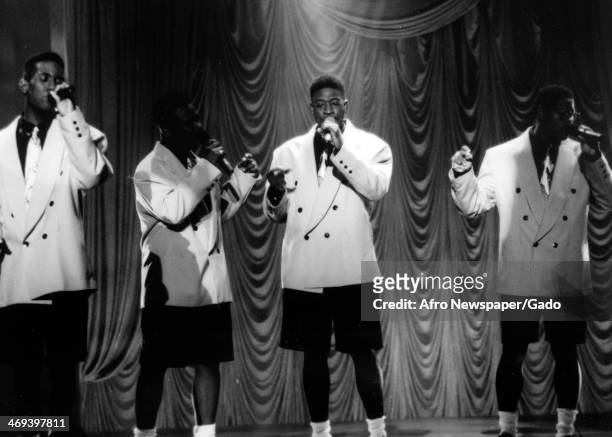 Four man singing group, Boyz II Men, specialists in R&B soul and acapella music, founded in 1988, on stage singing in white tuxedos and black shorts,...