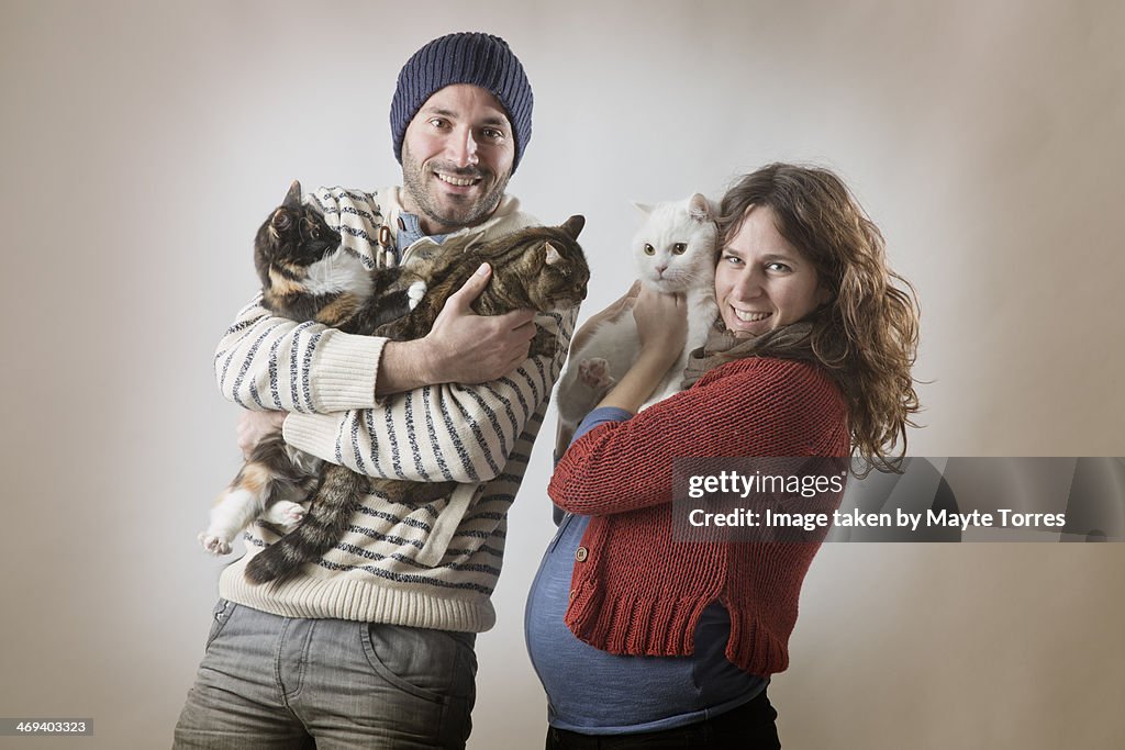 Family portrait with cats and pregnant woman