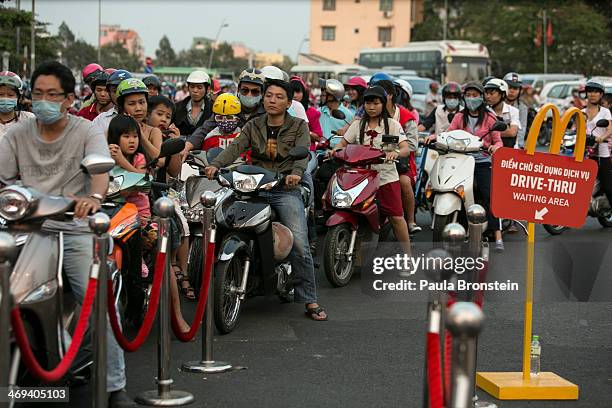 People line up waiting to park their motorcycles as they arrive at the new Mac Donald's restaurant in Ho Chi Minh city February 14, 2014. The first...