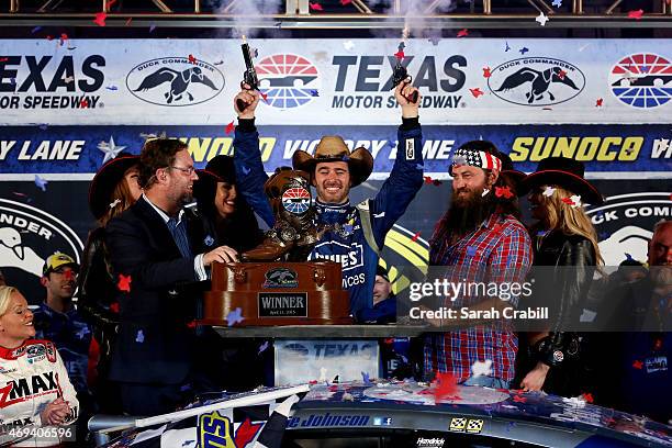 Jimmie Johnson, driver of the Lowe's Pro Services Chevrolet, celebrates with pistols in Victory Lane after winning the NASCAR Sprint Cup Series Duck...