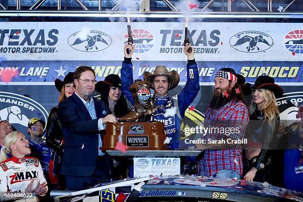 Jimmie Johnson, driver of the Lowe's Pro Services Chevrolet, celebrates with pistols in Victory Lane after winning the NASCAR Sprint Cup Series Duck...